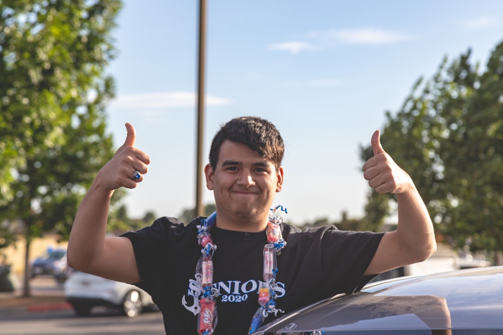 boy in black t-shirt raising his right hand