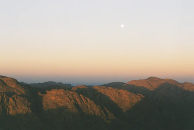 A peaceful mountain valley in Bhutan bathed in soft moonlight beneath twinkling stars.