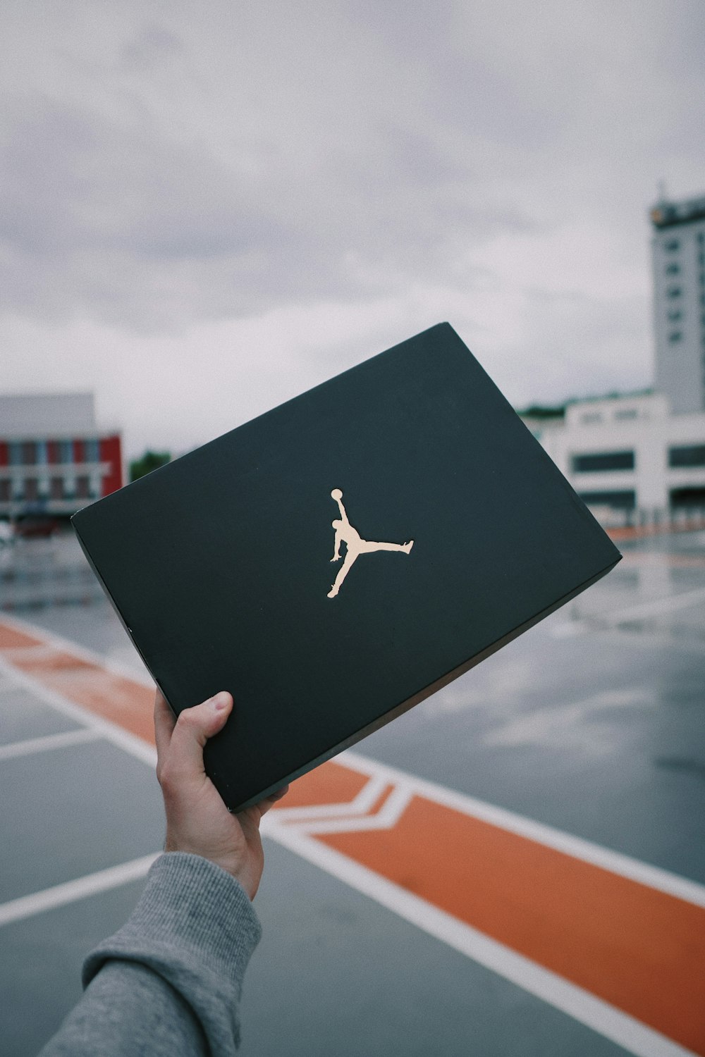 person holding black and white air jordan shoe box