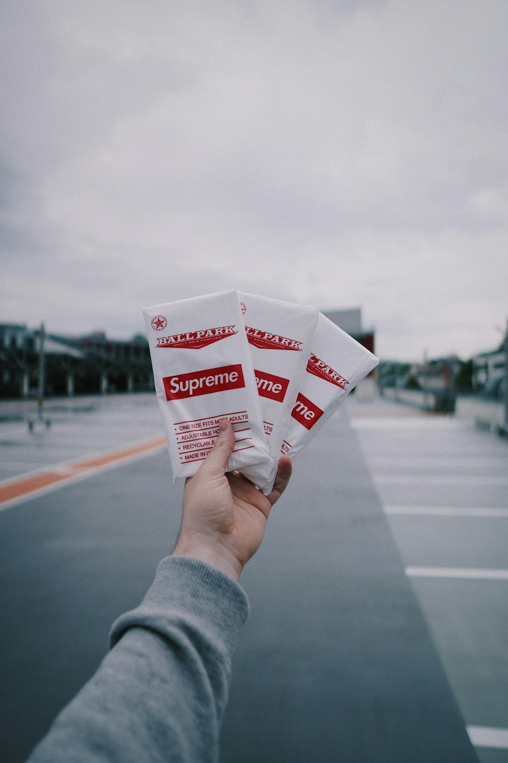 person holding white and red plastic pack