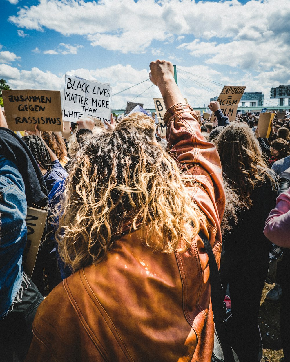 woman in brown long sleeve shirt raising her hands