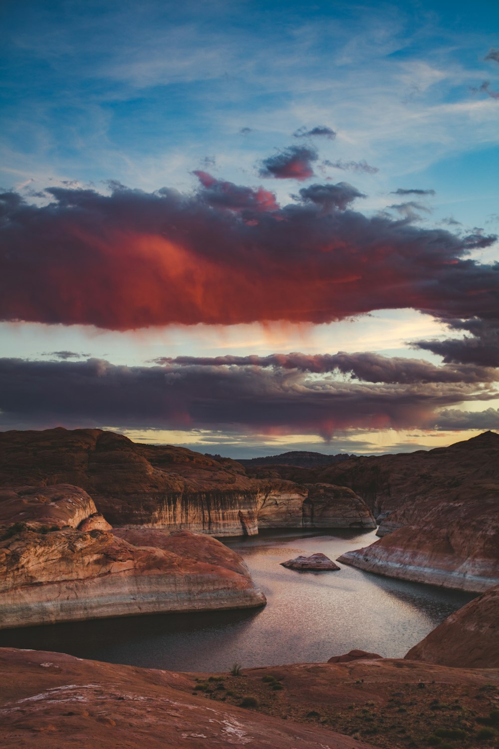 brown rocky mountain near body of water during sunset