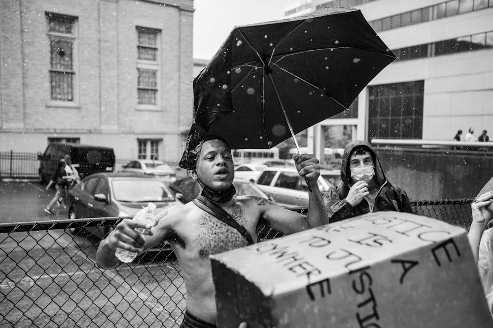 homme tenant un parapluie près d’une femme en veste noire