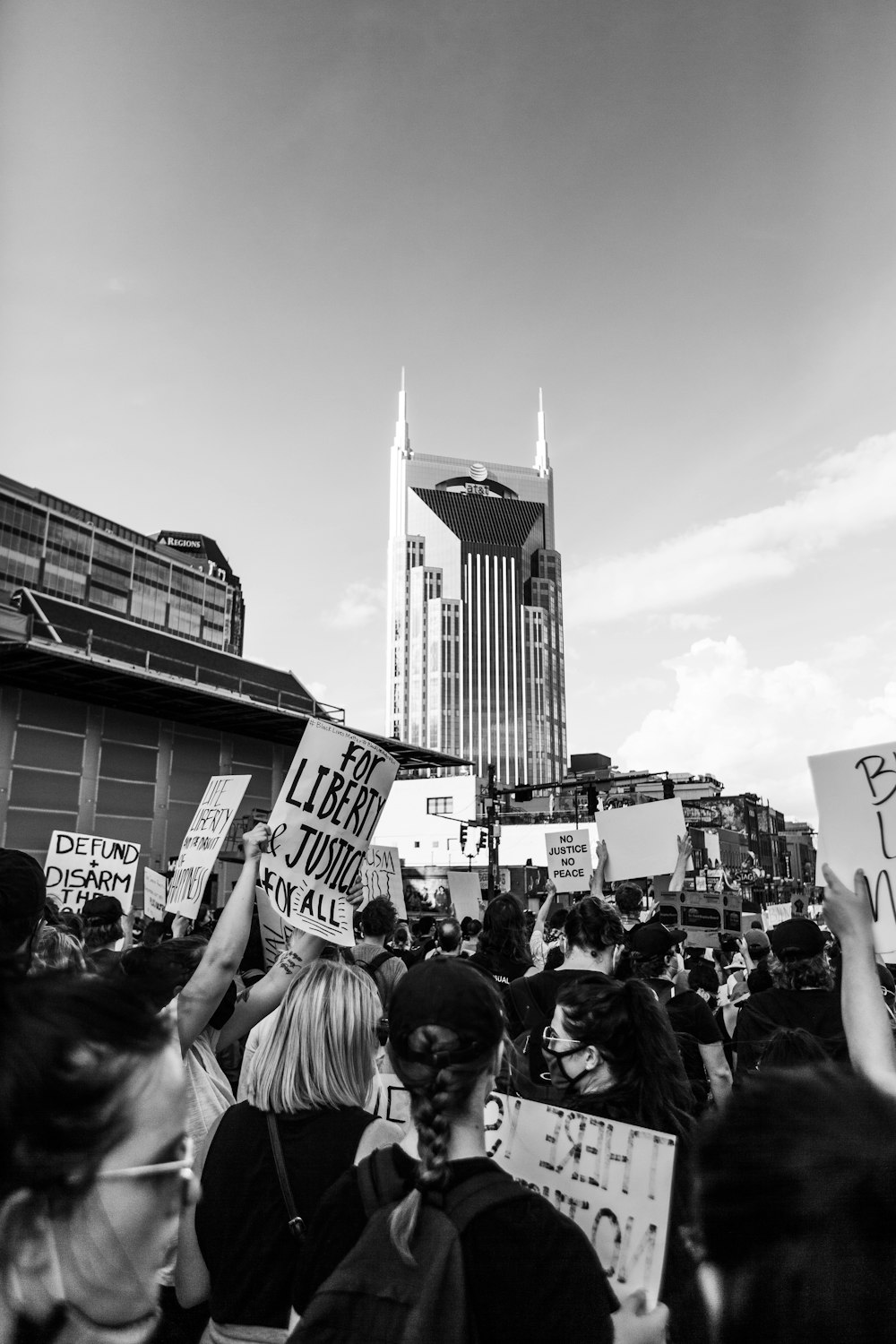 Foto en escala de grises de personas frente al edificio