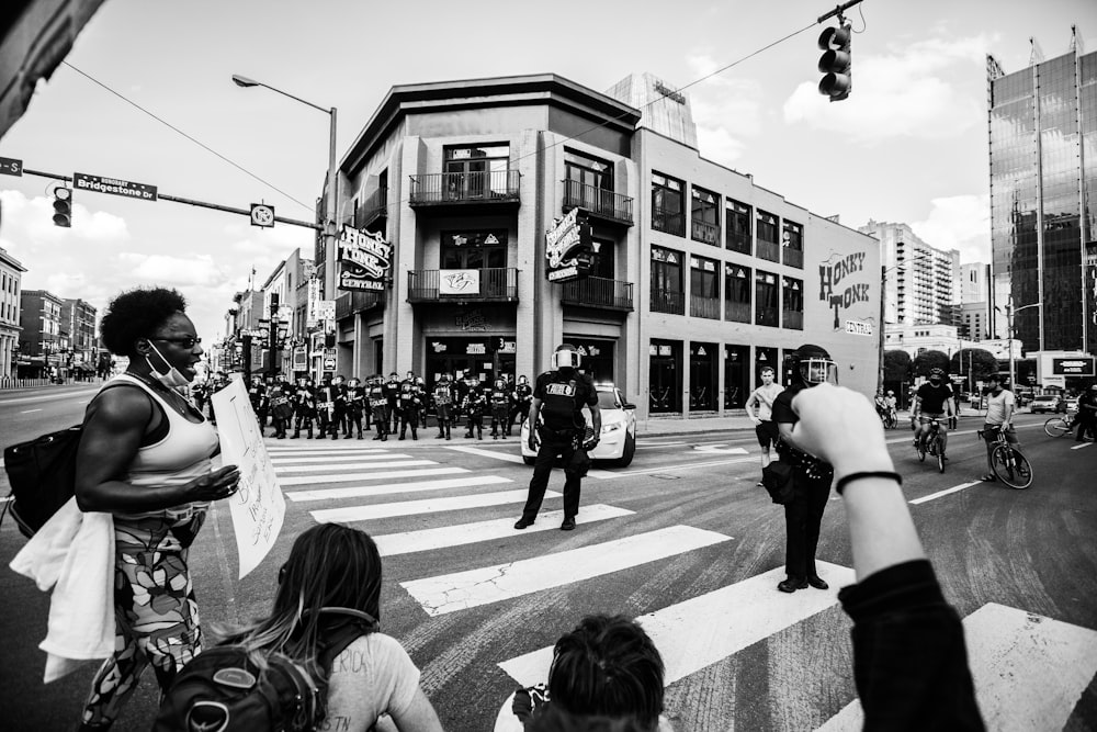 foto em tons de cinza de pessoas andando na faixa de pedestres