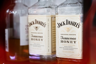 Several bottles are arranged side by side, prominently featuring Jack Daniel's Tennessee Honey whiskey with clear branding and labels in view.