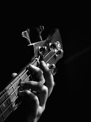 person playing guitar grayscale photo