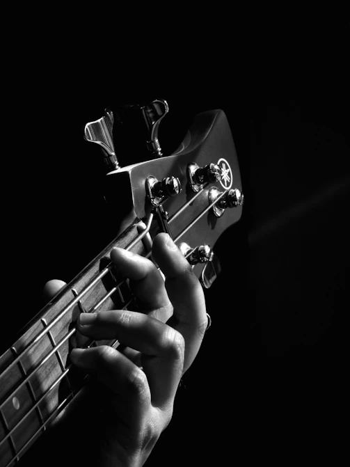 person playing guitar grayscale photo