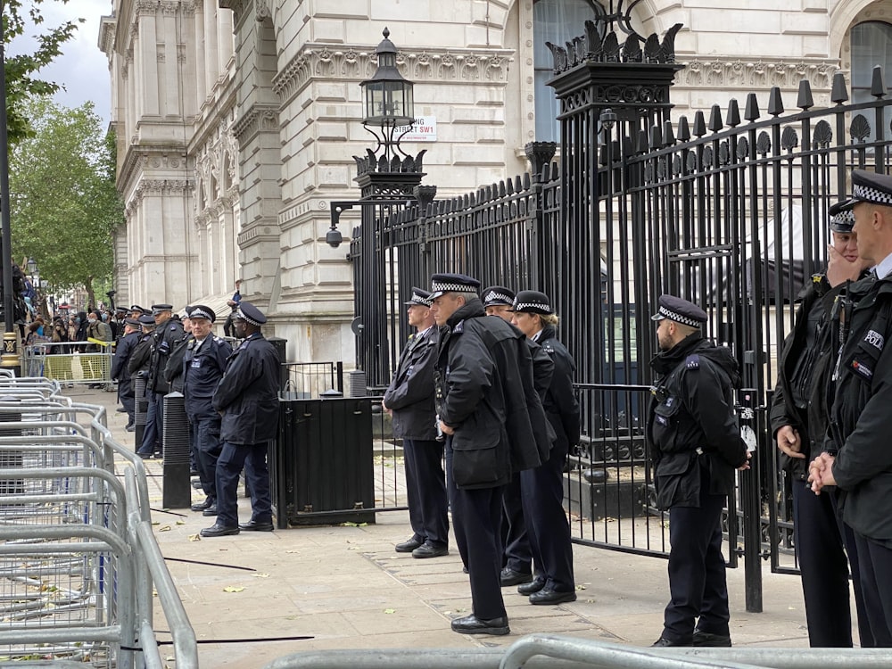 man in black coat standing near black metal gate during daytime