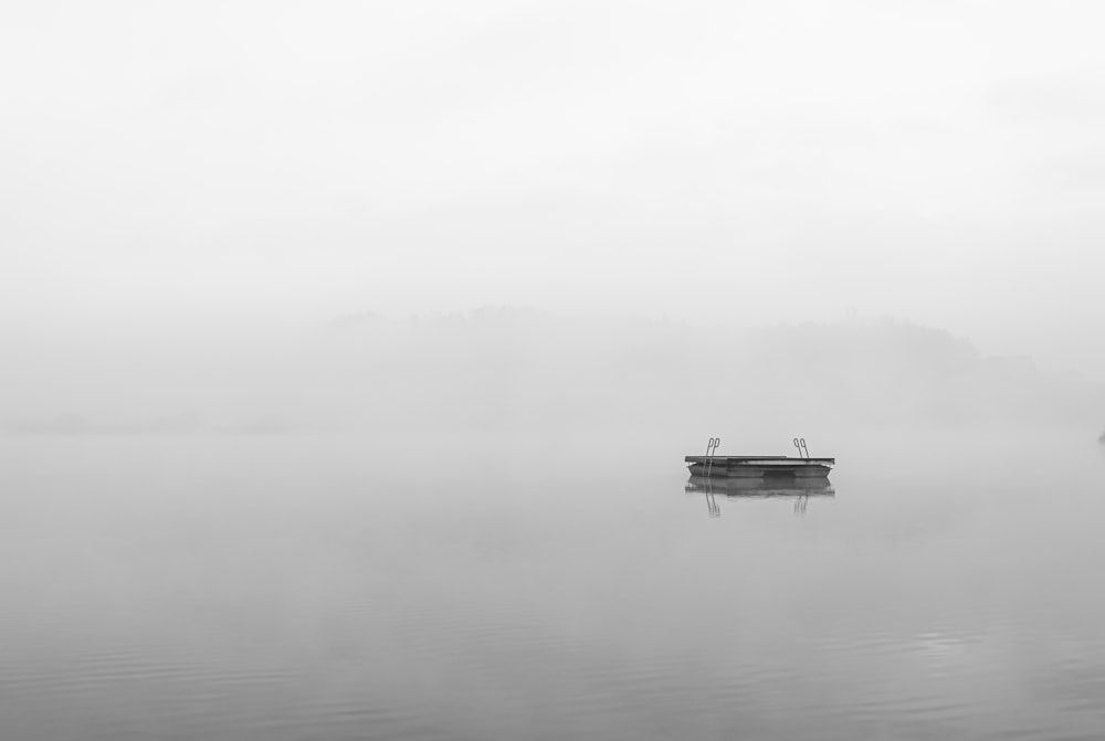 boat on calm water during foggy weather