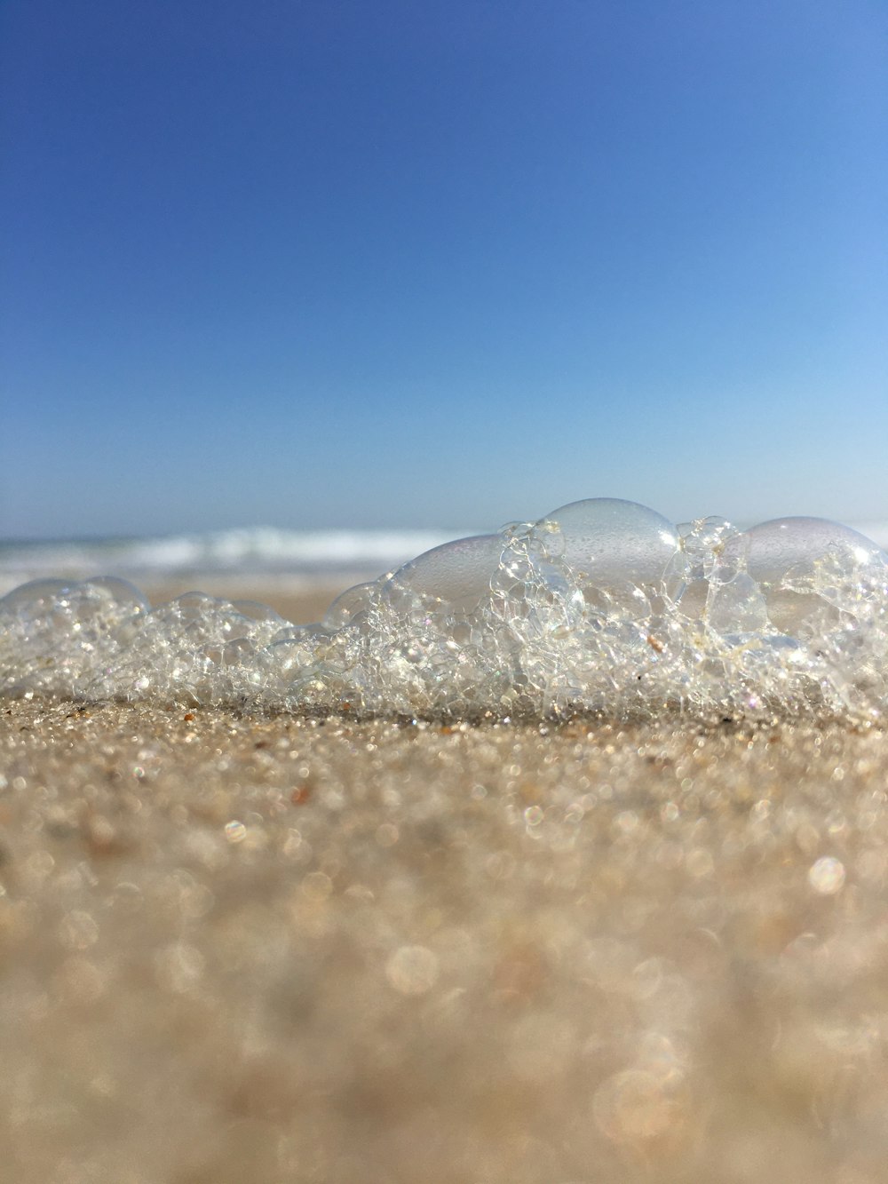 water bubbles on the shore during daytime