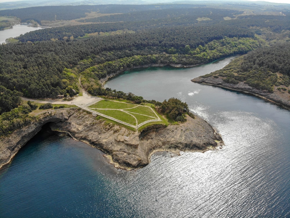 aerial view of green grass field near body of water during daytime