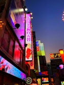 A vibrant neon-lit cityscape at night with glowing signs and reflections.