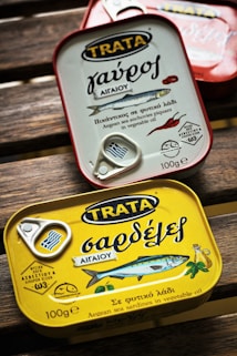 person holding yellow and white can