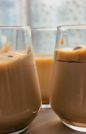 Barista pouring iced coffee with artistic foam in a bright, modern Phnom Penh cafe.