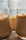 Three glasses filled with frothy iced coffee are closely positioned, highlighting the texture and creamy foam on top. Light softly filters through the background, creating a warm, inviting atmosphere.