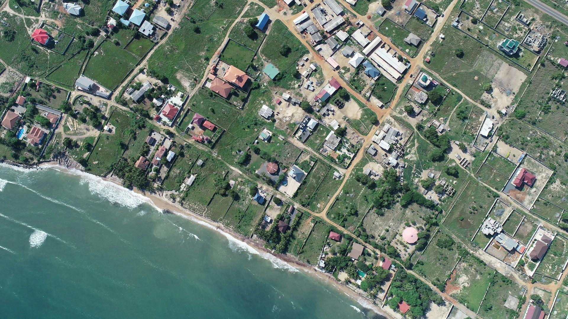 aerial view of houses near body of water during daytime