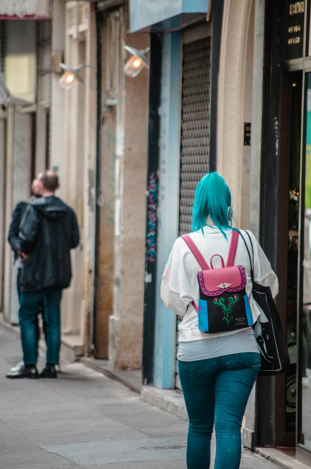 woman in white shirt and blue denim jeans with black and red backpack