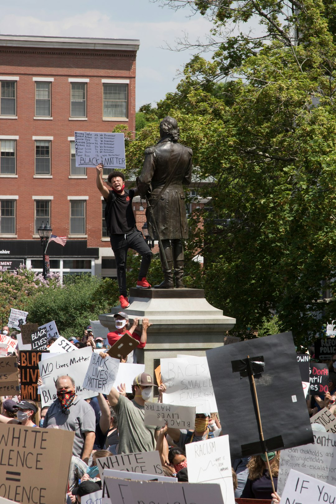 man in black leather jacket standing near statue during daytime