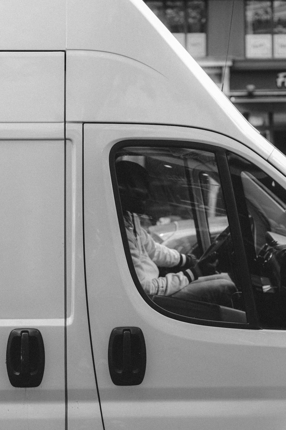 grayscale photo of man in car