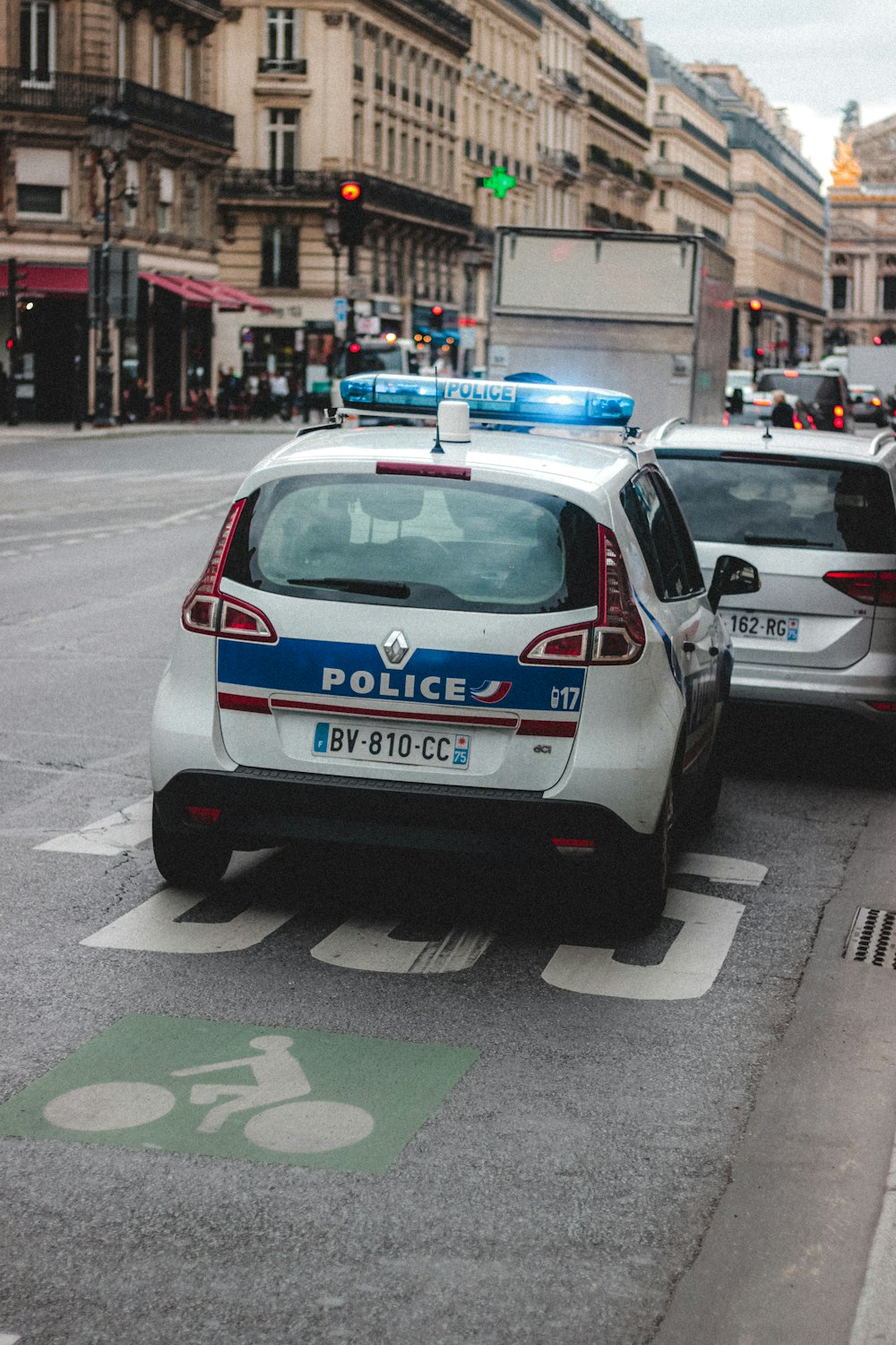 weißes und blaues Polizeiauto tagsüber unterwegs