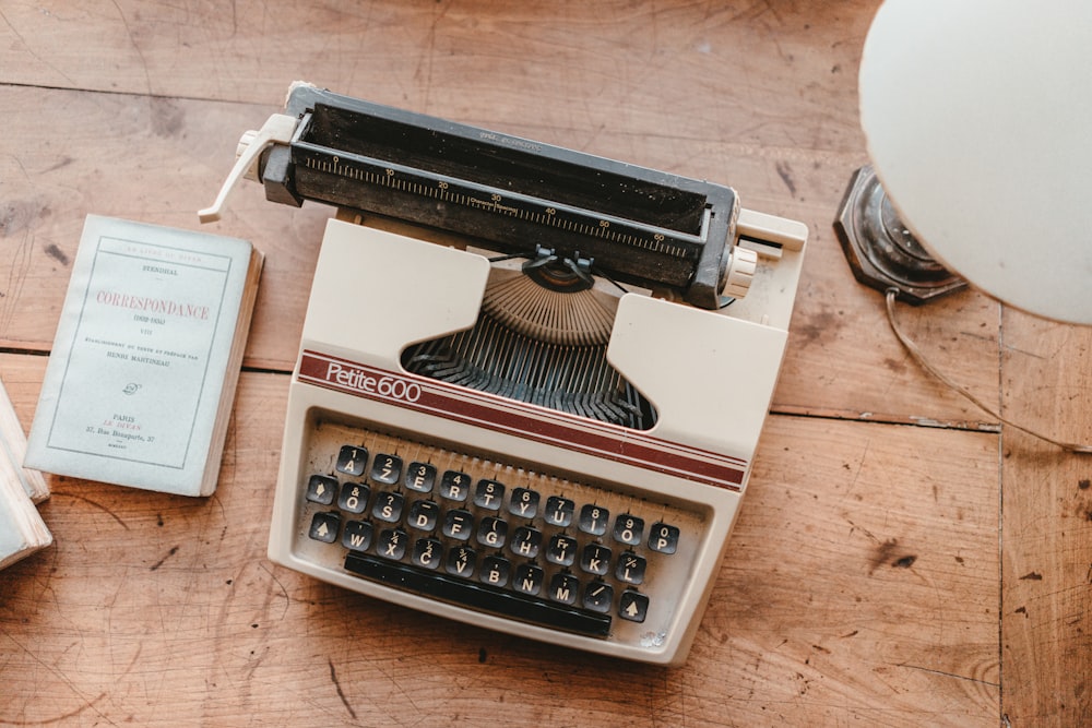 an old fashioned typewriter sitting on top of a wooden table