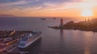 Sunset view of Tangier cruise port with large cruise ships docked, glowing warmly under golden light.