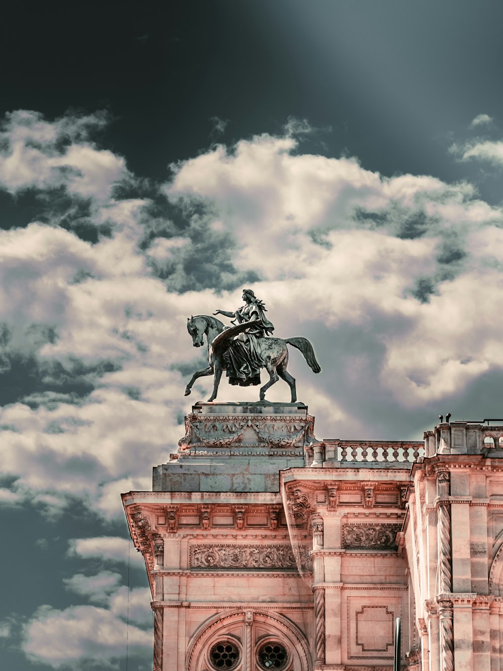 hombre montando estatua de caballo bajo el cielo nublado durante el día