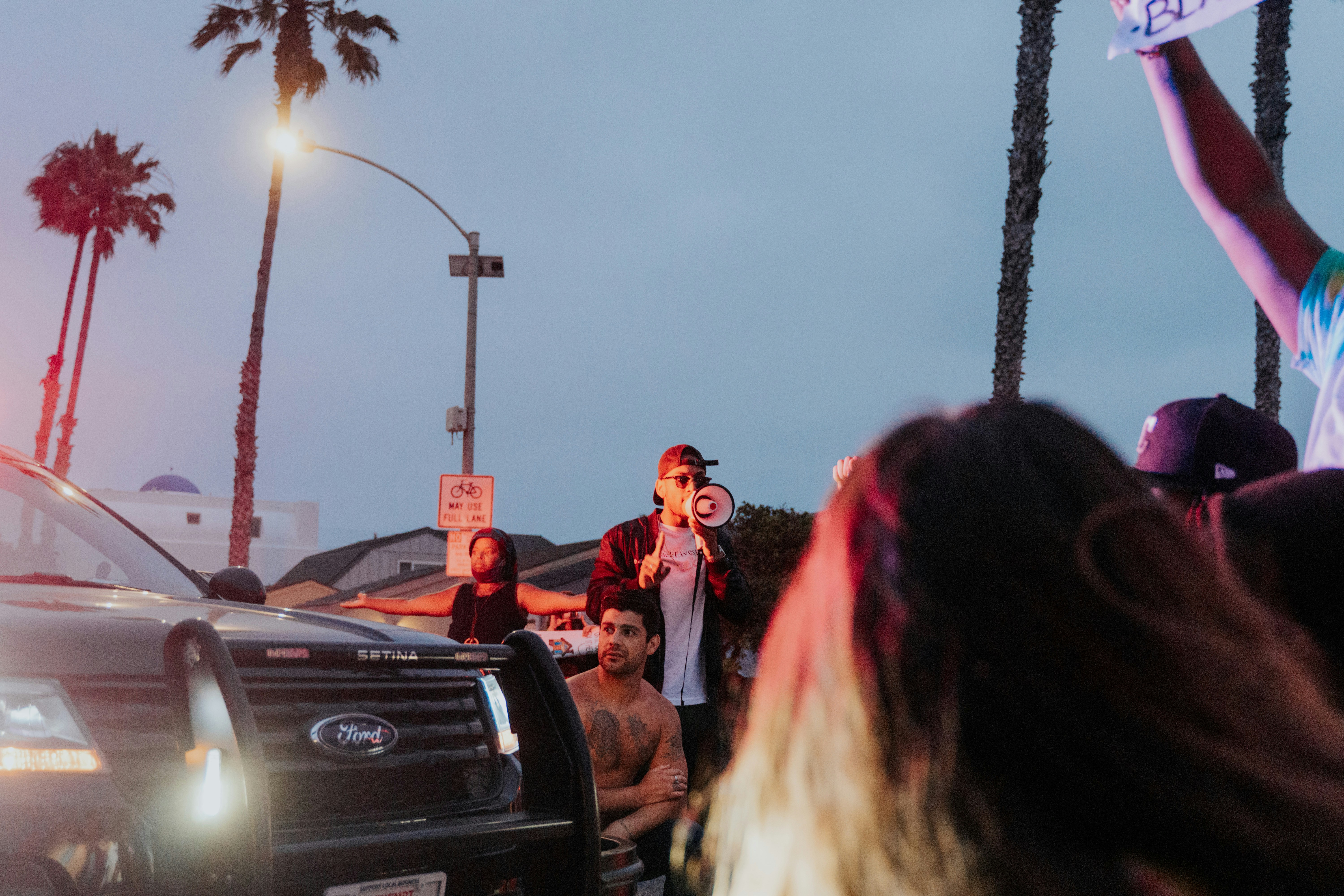 Crowd gathered around an electric pickup truck at an auto show, examining the exterior and interior