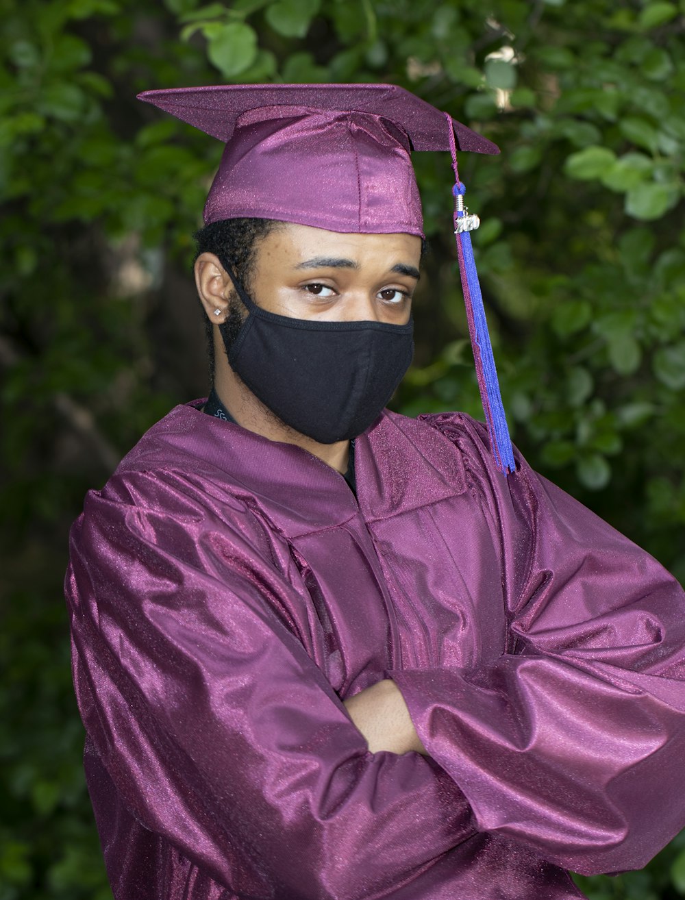 person in red academic robe wearing black hijab