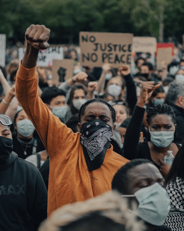 man in orange shirt wearing black mask