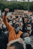 man in orange shirt wearing black mask