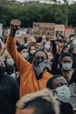 man in orange shirt wearing black mask