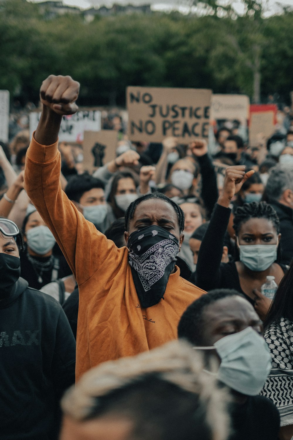 man in orange shirt wearing black mask