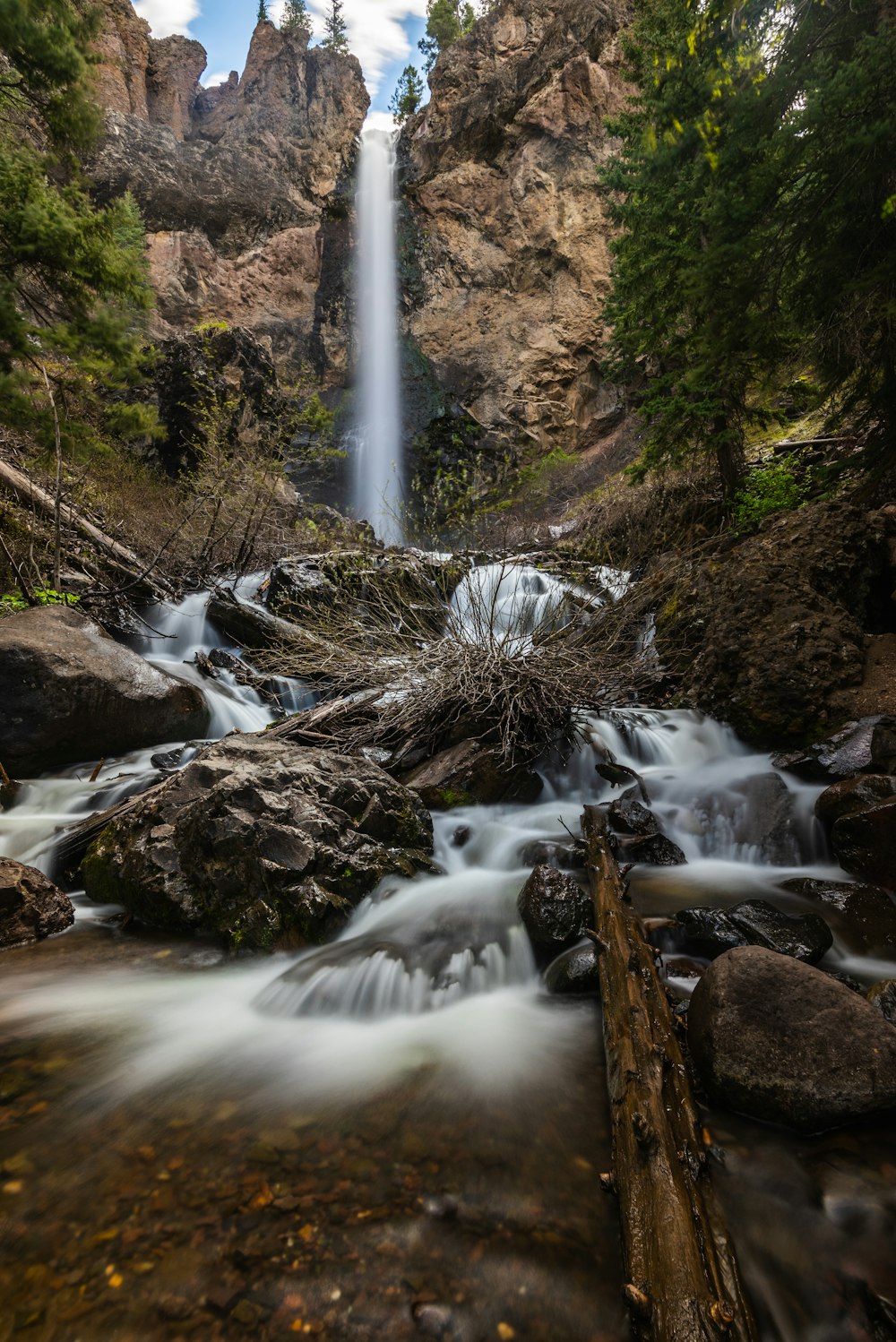 water falls on brown rocky mountain during daytime