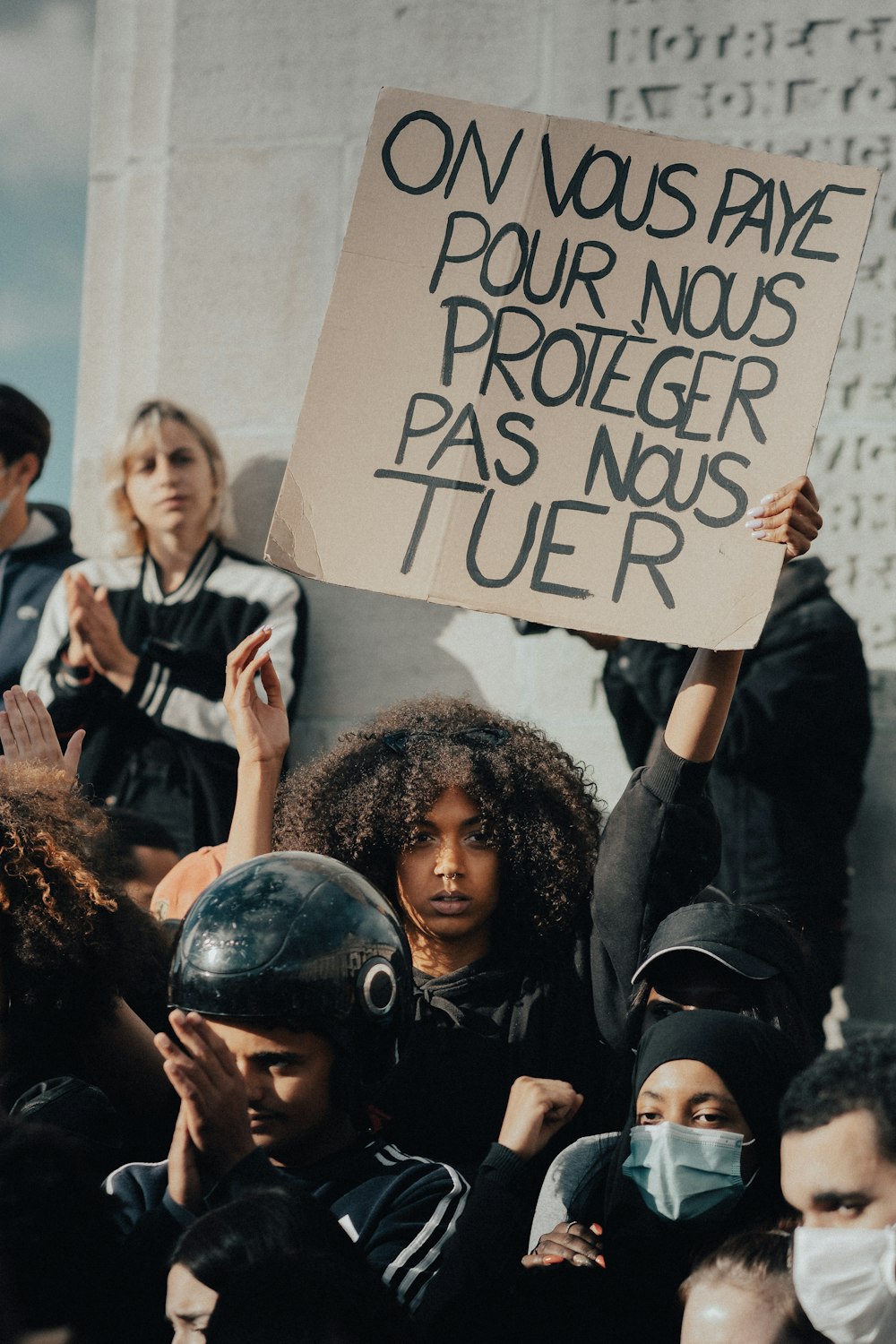 Femme en veste noire tenant du papier d’imprimante blanc