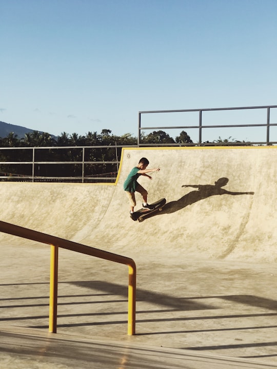 man in black t-shirt and black pants doing skateboard stunts on brown sand during daytime in Payakumbuh Indonesia