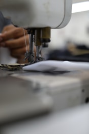 person in white shirt sewing machine