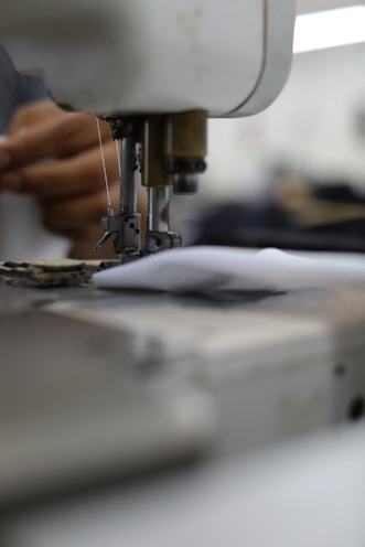 person in white shirt sewing machine