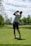 man in white t-shirt and black shorts holding golf club