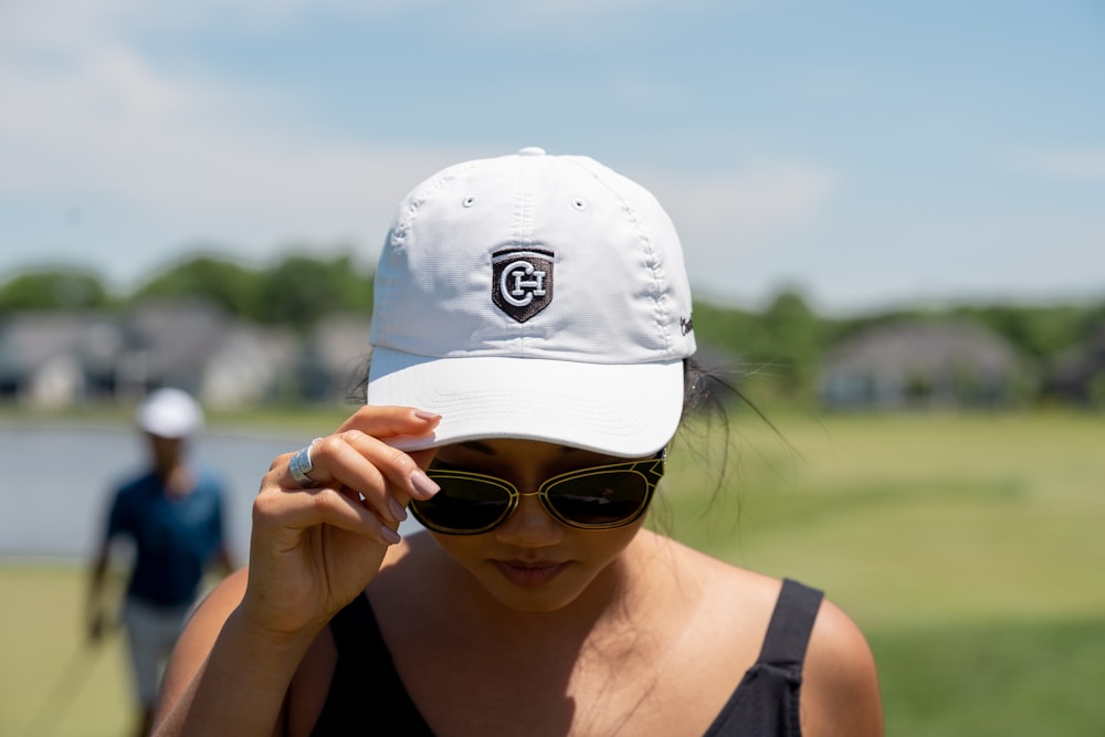 woman in black tank top wearing white cap and white sunglasses