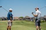man in blue t-shirt and gray shorts playing golf during daytime