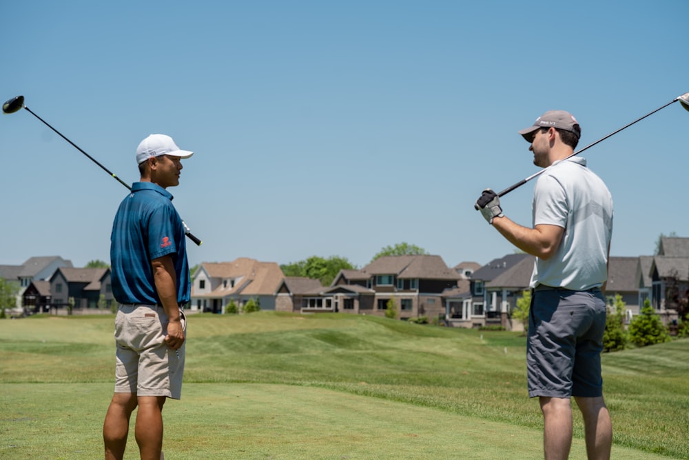 man in blue t-shirt and gray shorts playing golf during daytime