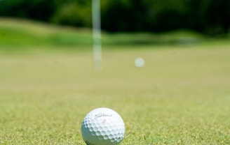 white golf ball on green grass field during daytime