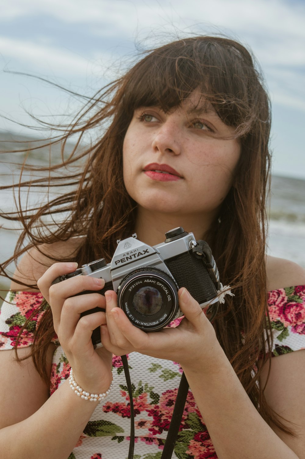 woman holding black and silver nikon dslr camera