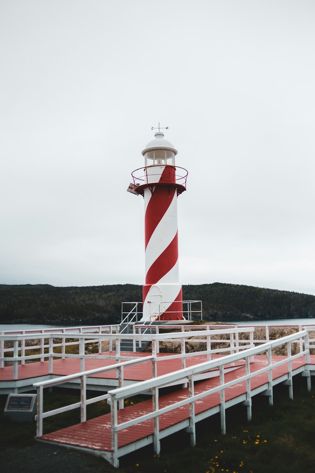 white and red striped lighthouse under cloudy sky during daytime