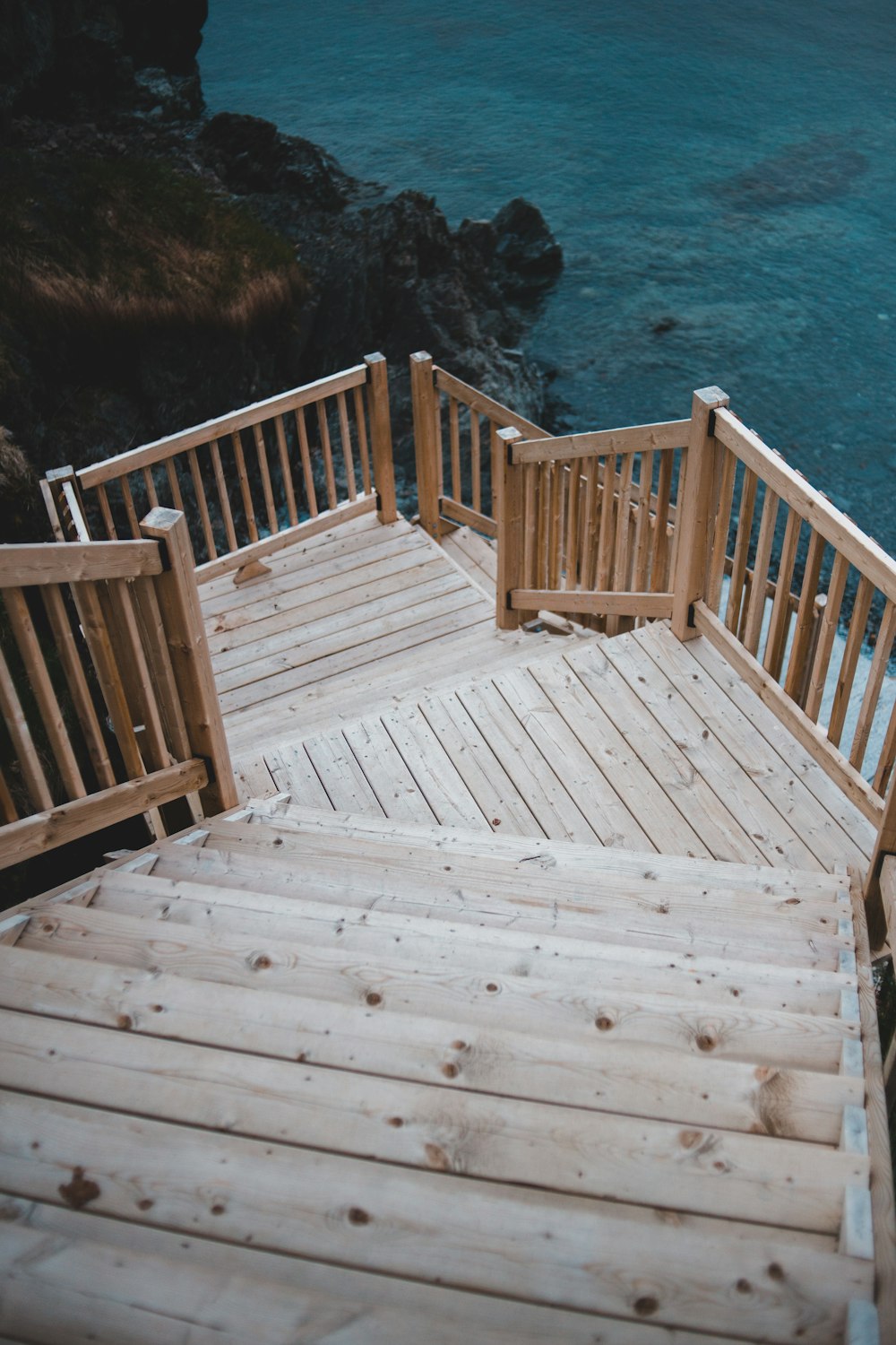 brown wooden bridge over blue sea during daytime