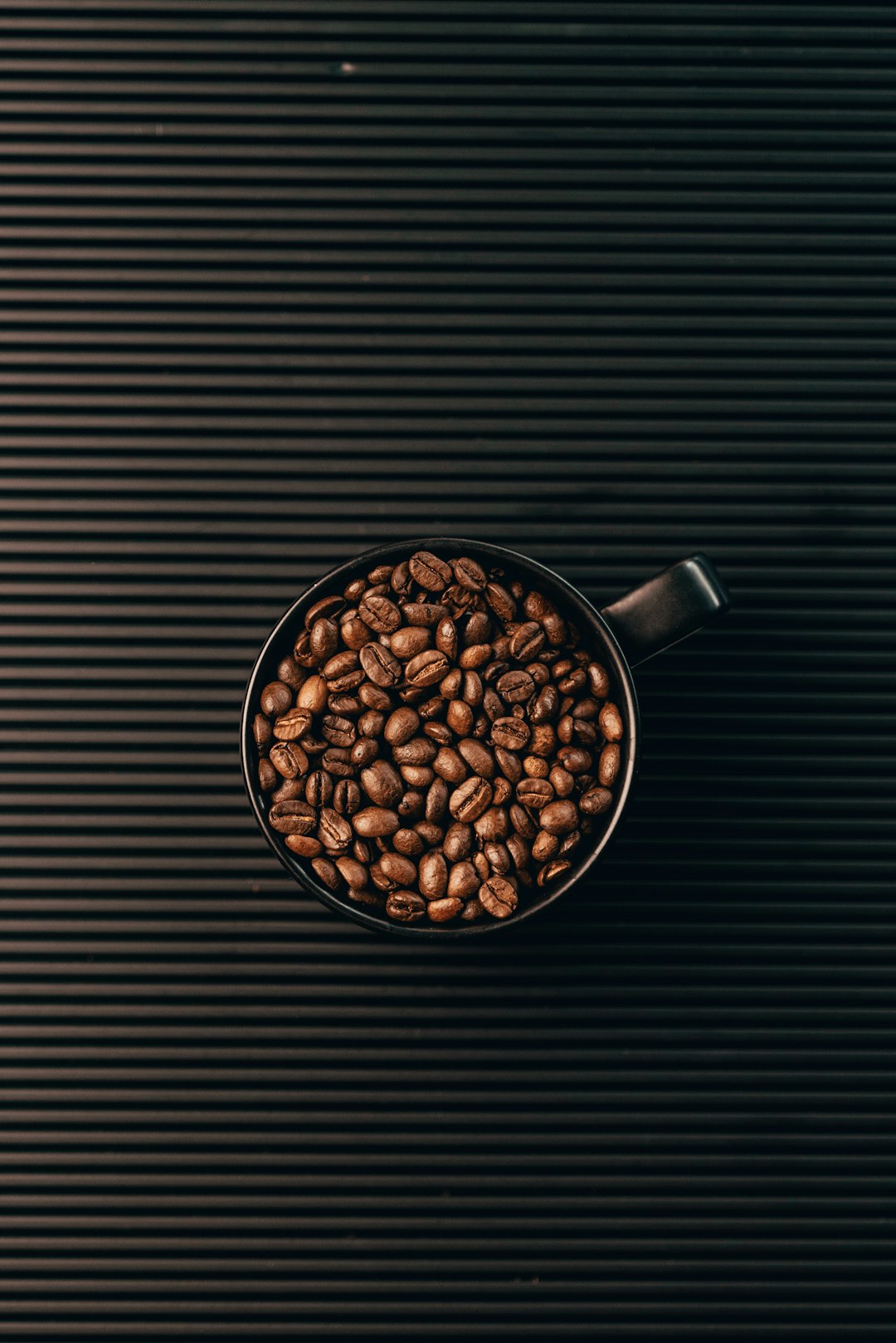 coffee beans in black ceramic mug