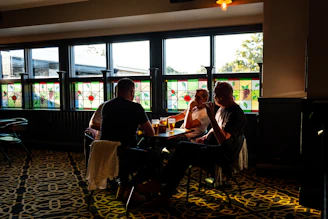 A cozy pub setting with small groups enjoying 'Poems and Pints,' exchanging verses over drinks.