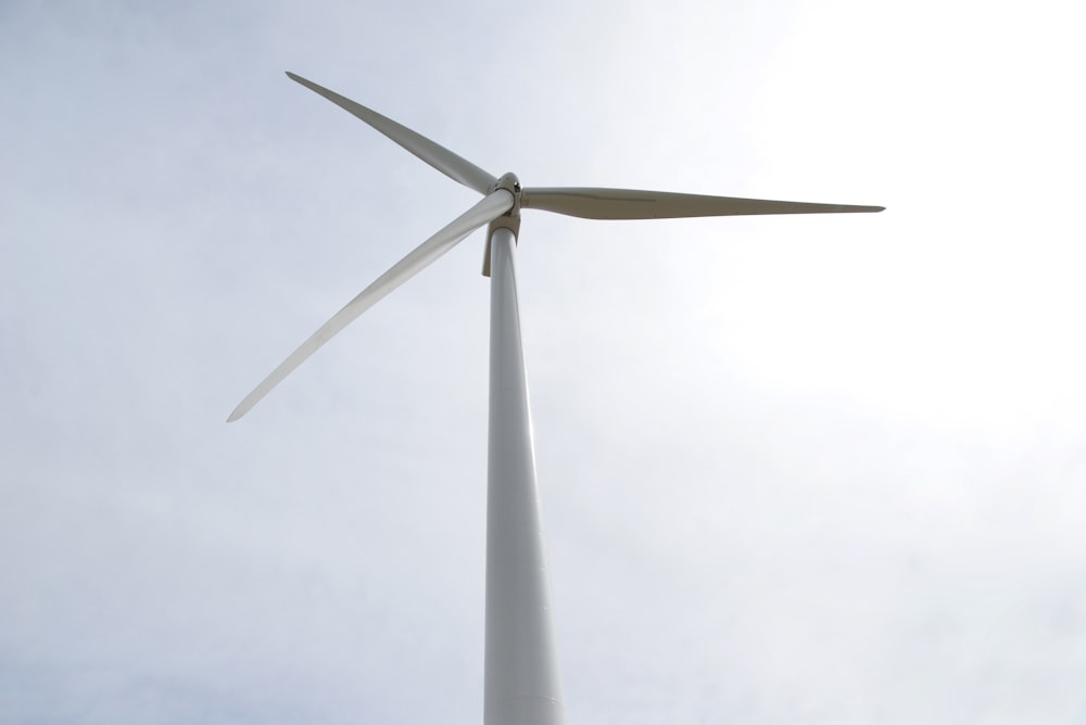 white wind turbine under white sky